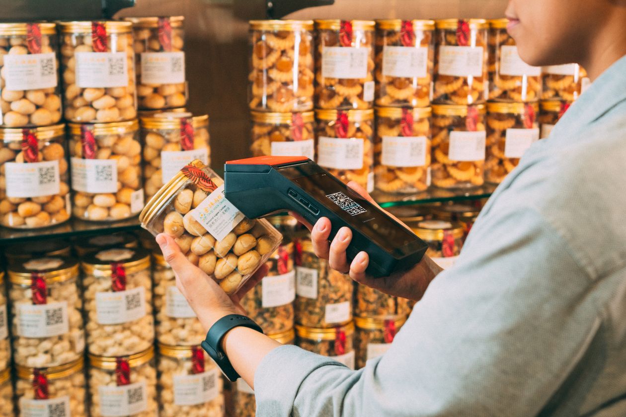 Barcode scanning a product at a retail store counter in Pakistan