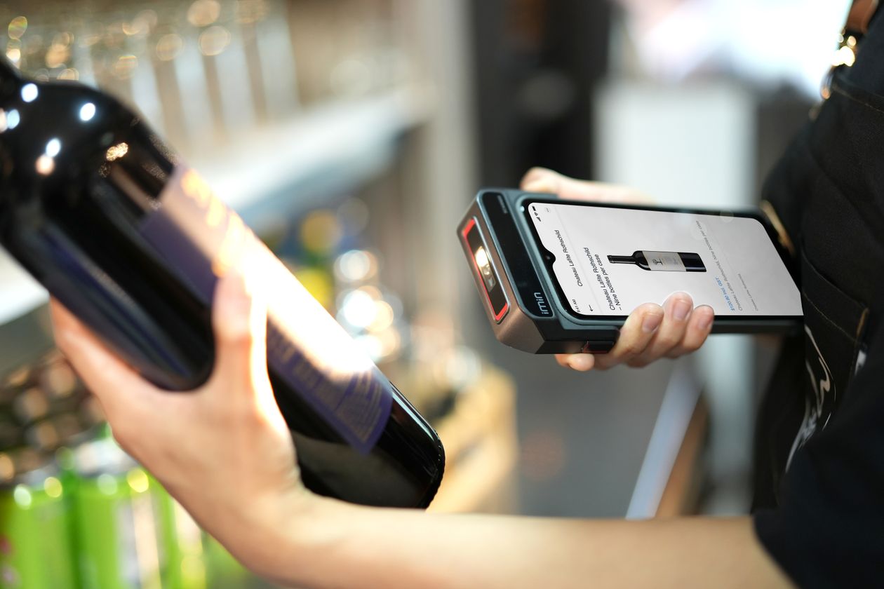 Staff scanning a product to check batch and expiry details in a store