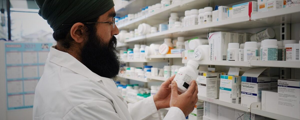 Pharmacist checking medicine expiry dates on pharmacy shelves