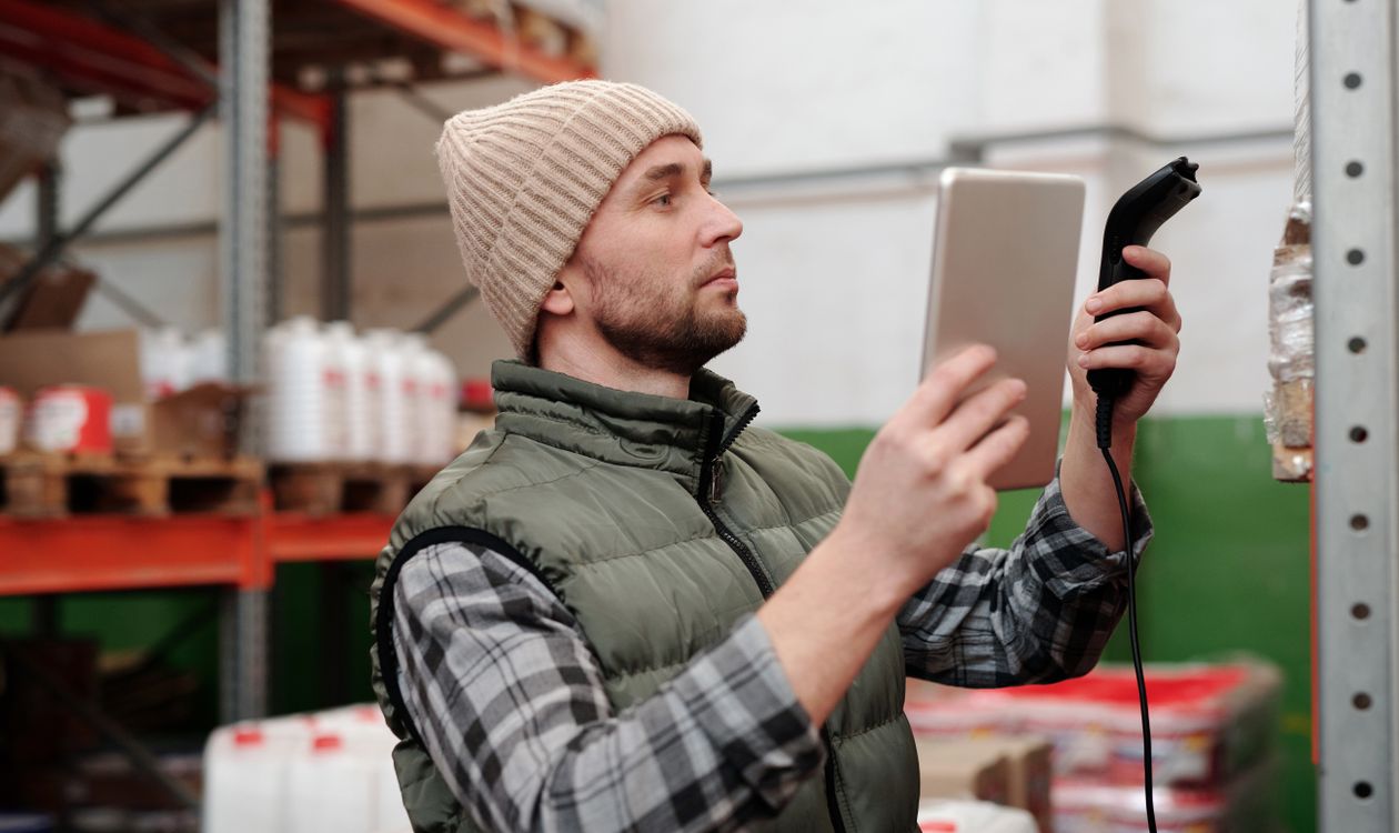 Shop owner checking stock levels against a sales report in a retail store