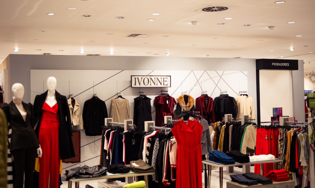 Boutique clothing display with garments organised by style and colour