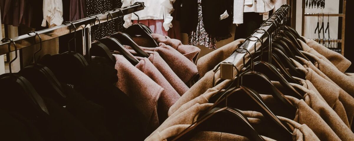 Clothing store racks showing garments in multiple sizes and colours
