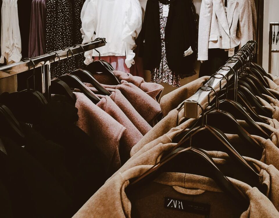 Clothing store racks showing garments in multiple sizes and colours