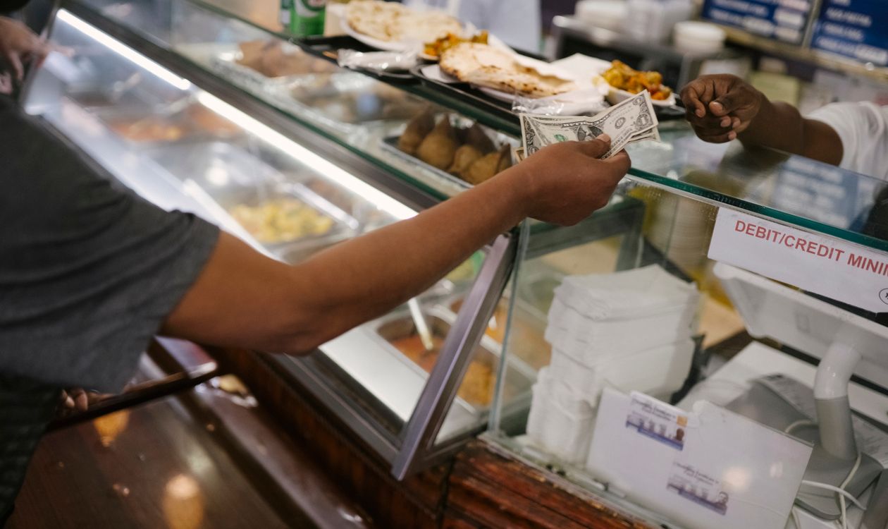 Customer paying a bill at a cafe counter where PRA sales tax applies